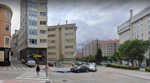 un grupo de personas cruzando una calle en una ciudad en Orzan Beach Surf Apartment, en A Coruña