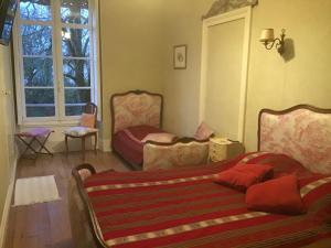 sala de estar con 2 camas y ventana en Château Saint Vincent, en Bazas
