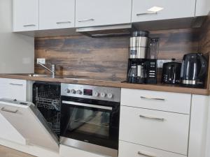a kitchen with white cabinets and an oven at Zentrum,Modern,Silently,New Property,Parking Place,Netflix in Wetzlar
