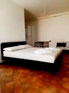 - une chambre avec un lit avec des draps blancs et une table dans l'établissement Il vicolo By Turistica, à Domodossola