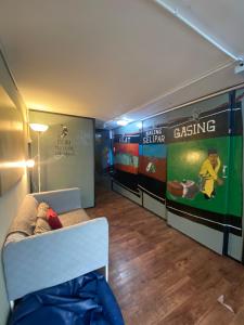 a living room with a couch and posters on the wall at Hikers Sleep Port Guesthouse in Cameron Highlands