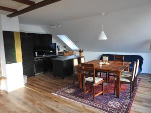 a kitchen and dining room with a wooden table and chairs at Ferienwohnung Narziss in Bad Kissingen