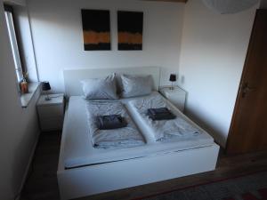 a white bed with two pillows on it in a room at Ferienwohnung Narziss in Bad Kissingen