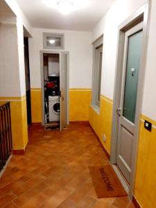 einen Flur mit gelben und weißen Wänden und einer Tür in der Unterkunft Il vicolo By Turistica in Domodossola
