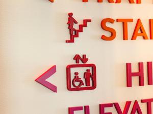 a sign on a wall with a fire hydrant and a man and a person at Motel L Hammarby Sjöstad in Stockholm