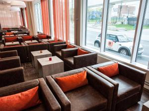 a restaurant with couches and tables and a car in the window at Motel L Hammarby Sjöstad in Stockholm