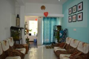 ein Wohnzimmer mit zwei Sofas und einem Herz an der Wand in der Unterkunft EDEN Paradisee in Udagamandalam