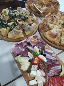 um grupo de pizzas numa mesa com pizza em Seosko domacinstvo Imunsan em Niš