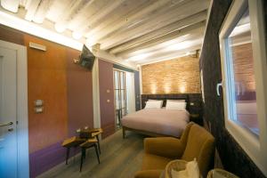 a bedroom with a bed and a couch and a chair at Casa Sansera in Chioggia