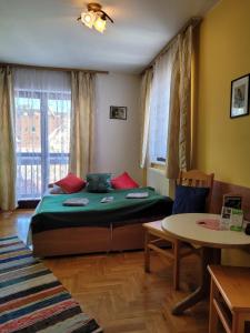 1 dormitorio con 1 cama y 1 mesa en una habitación en Podhalanka Pokoje en Zakopane
