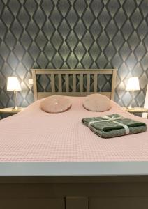 1 cama con sábanas y almohadas rosas y 2 lámparas en AppartUnique - Chez Helder, la suite ! en Vichy