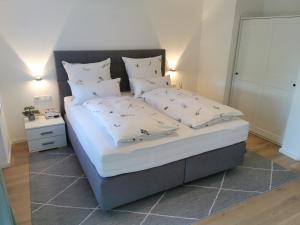 een slaapkamer met een bed met witte lakens en kussens bij Ferienwohnung Wiesenblick in Bad Hindelang