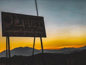 Lagona Dahab Hotel في دهب: علامة على قمة جبل عند غروب الشمس