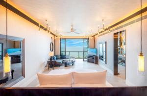 a living room with a couch and a view of the ocean at Baba Beach Club Hua Hin Luxury Pool Villa by Sri panwa in Cha Am