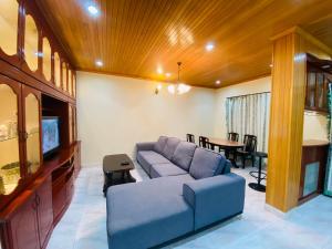 a living room with a blue couch and a tv at 100 Oastel coLiving in Tanah Rata