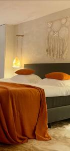 a bedroom with a bed with an orange blanket on it at VILLA FER-GUY " Beeldige Suite met parking, nabij strand en casino" in Knokke-Heist