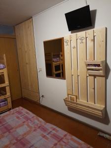 Habitación con cama y TV en la pared. en Monolocale cimarosa, en Caspoggio