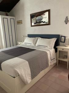 1 dormitorio con 1 cama grande y cabecero azul en B&B Le Tre Casette, en Maratea