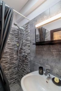 un bagno con doccia e lavandino bianco di Pensiunea Doro a Caciulata