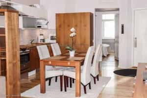 a kitchen and dining room with a wooden table and white chairs at 2ndhomes 1BR Charming City apartment in Yrjönkatu in Helsinki