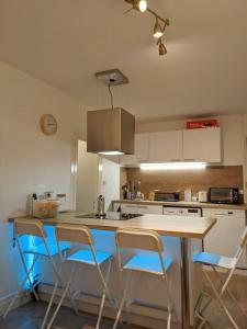 a kitchen with a table and chairs in it at Séjour cocooning pour se ressourcer à la montagne. in Aulus-les-Bains