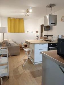 uma cozinha e sala de estar com um sofá e uma mesa em Séjour cocooning pour se ressourcer à la montagne. em Aulus-les-Bains