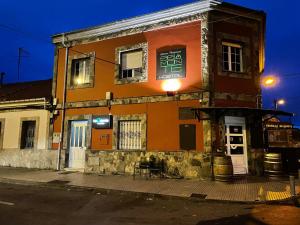 an orange building on the corner of a street at Pensión Belmonte - check in Hotel a 650 metros in Gijón