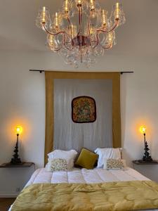 - une chambre avec un grand lit et un lustre dans l'établissement les croix appartements, à Morlaix