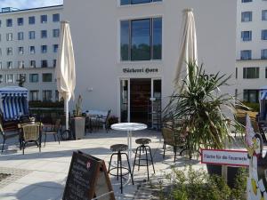 un patio con sillas, mesas y sombrillas frente a un edificio en Haus Arkona - Meeresrausch, en Binz