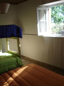 a bedroom with a bed with a window and a bedspread at Shanti Hostel in San Rafael