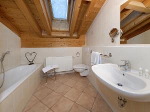 a bathroom with a tub and a toilet and a sink at Gästehaus Bernhard in Krün +24 photos