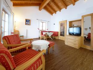 a living room with a tv and a couch and a table at Gästehaus Bernhard in Krün
