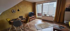 ein Wohnzimmer mit Tisch und Stühlen und einem Fernseher in der Unterkunft Aaron IV inkl Bettwäsche Handtücher Endreinigung in Hahnenklee-Bockswiese