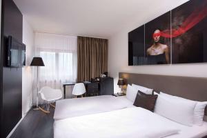 a hotel room with a bed and a desk at Wyndham Stuttgart Airport Messe in Stuttgart
