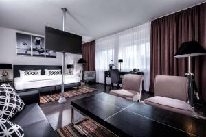 a hotel room with a bed and a living room at Wyndham Stuttgart Airport Messe in Stuttgart