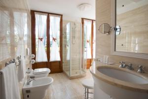 a bathroom with a sink and a toilet at Augustus Hotel & Resort in Forte dei Marmi