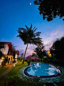 una piscina en un patio con una palmera en Moonstone Villas, en Tangalle