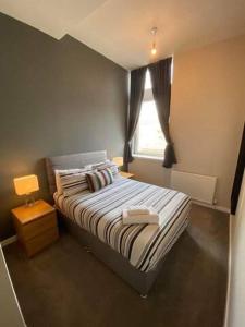 a small bedroom with a bed and a window at Dreamhouse at Oswald Street, City Centre in Glasgow