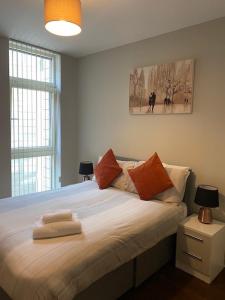 a bedroom with a large white bed with two lamps at Dreamhouse at Oswald Street, City Centre in Glasgow