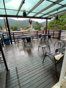 une terrasse en bois avec des tables et des chaises. dans l'établissement Coração Do Oceano Village & SPA, à Penha