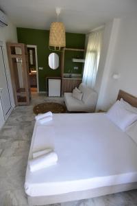 a bedroom with a large white bed and a couch at Haus Risos Next Generation in Toroni