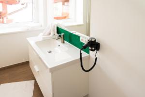a bathroom with a white sink with a greenabinet at Ramsau Appartements Pickl in Ramsau am Dachstein