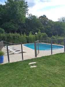 een hek rond een zwembad in een tuin bij al pie del morro in Merlo