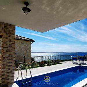 a swimming pool with a view of the ocean at Vista Villas - Lazy Days Apartment Villa N in Ražanac