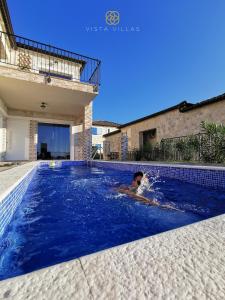 een man zwemmend in een zwembad in een huis bij Vista Villas - Lazy Days Apartment Villa N in Ražanac