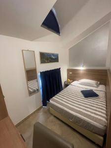 Hotel Montecarlo في ميلانو: غرفة نوم بسرير كبير ومرآة