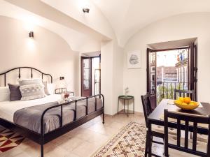 una camera con un letto e un tavolo con un cesto di frutta di Apartamentos Plaza Mayor 35 a Cáceres