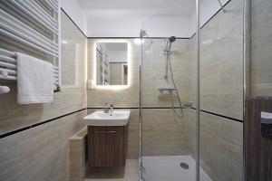 施柯拉爾斯卡波倫巴的住宿－Apartamenty EverySky - Osiedle Podgórze 1D，一间带玻璃淋浴和水槽的浴室
