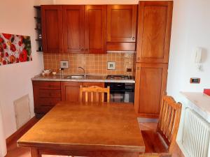 uma cozinha com armários de madeira e uma mesa de madeira em Villa Kalura D em Cefalù