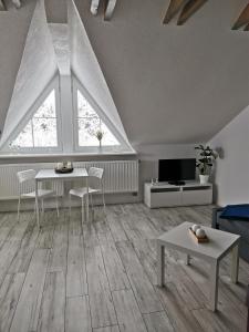 sala de estar con 2 mesas y TV en Ferienwohnung "Am Wald", en Schmiedefeld am Rennsteig